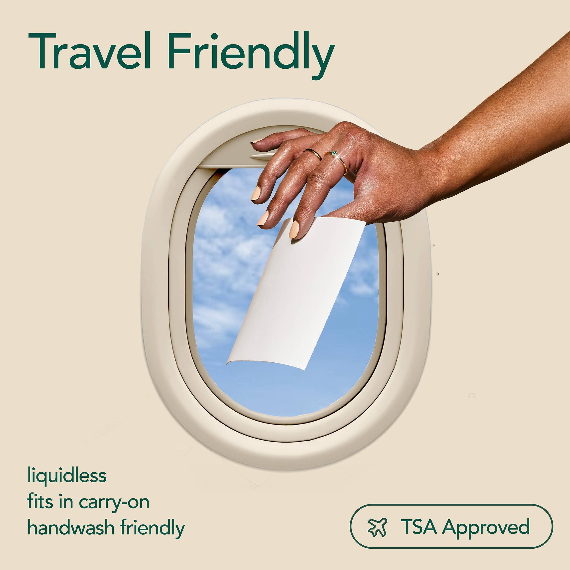 A person holding a ind laundry detergent sheet above an airplane cabin window. 