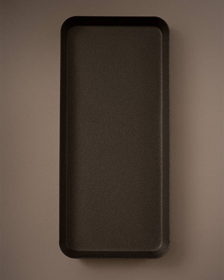Black rectangular tray on a brown background