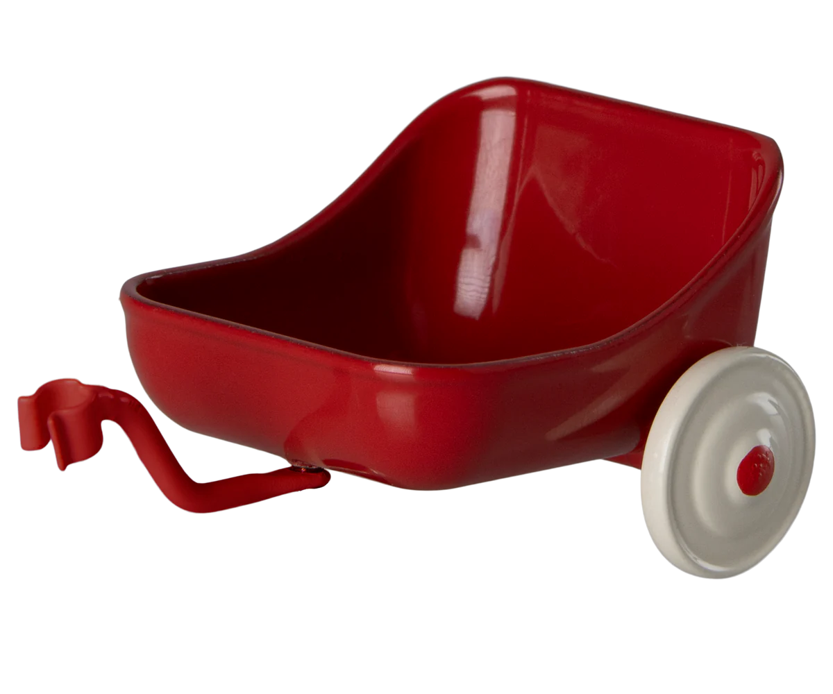 A red metal tricycle hanger with a white wheel, designed to be attached to a tricycle for additional storage.