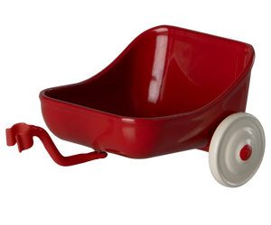 A red metal tricycle hanger with a white wheel, designed to be attached to a tricycle for additional storage.