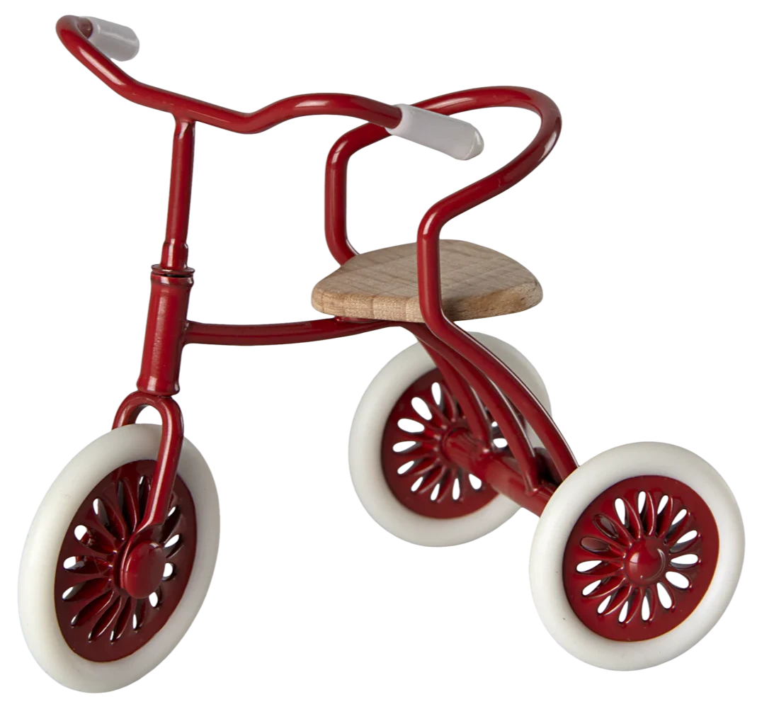 A red tricycle with wooden seat and rubber wheels, designed for young children.