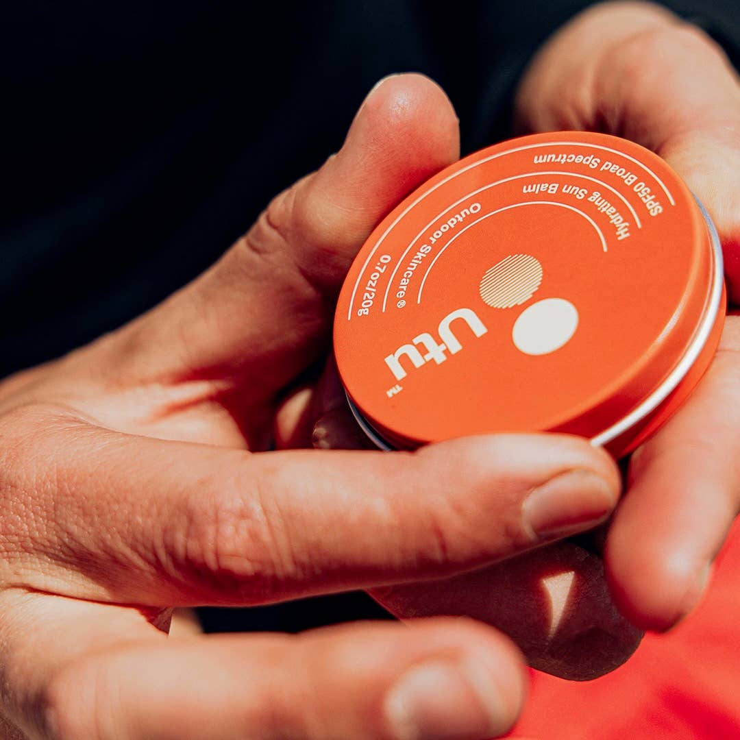 Person holding an orange container with 'utu' branding