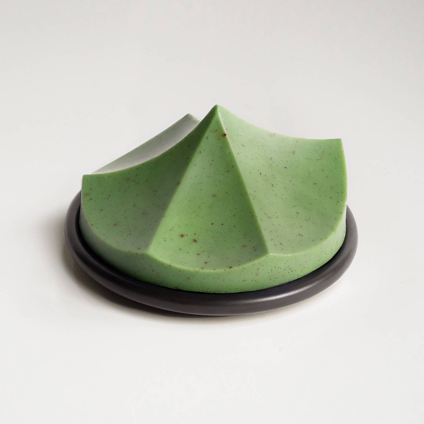 A green ume studios soap on a black bouton. 