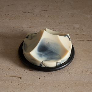 A luscious cold-process soap with a unique shape, featuring white and blue swirls, resembling a natural formation or floral pattern.