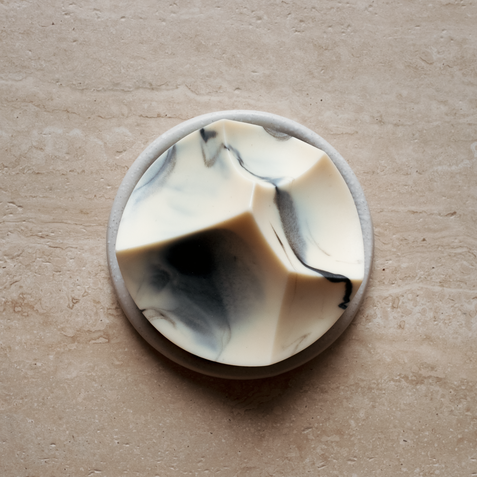 A luscious cold-process soap with a unique shape, featuring white and blue swirls, resembling a natural formation or floral pattern.