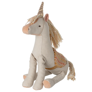 Stuffed unicorn toy with decorative elements on a white background