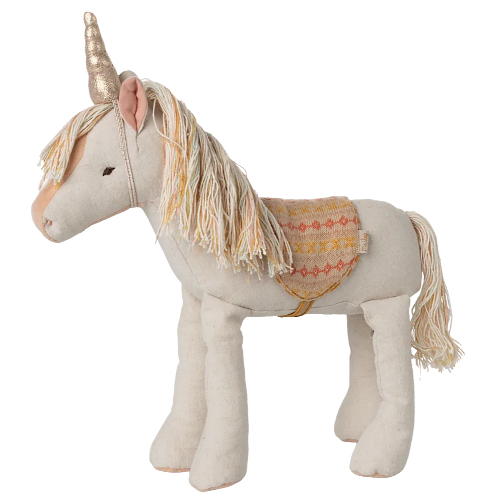 Stuffed unicorn toy with decorative saddle on a white background
