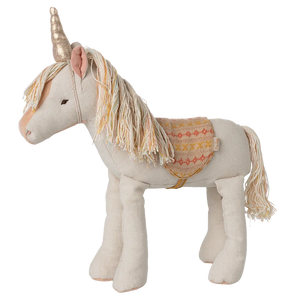 Stuffed unicorn toy with decorative saddle on a white background