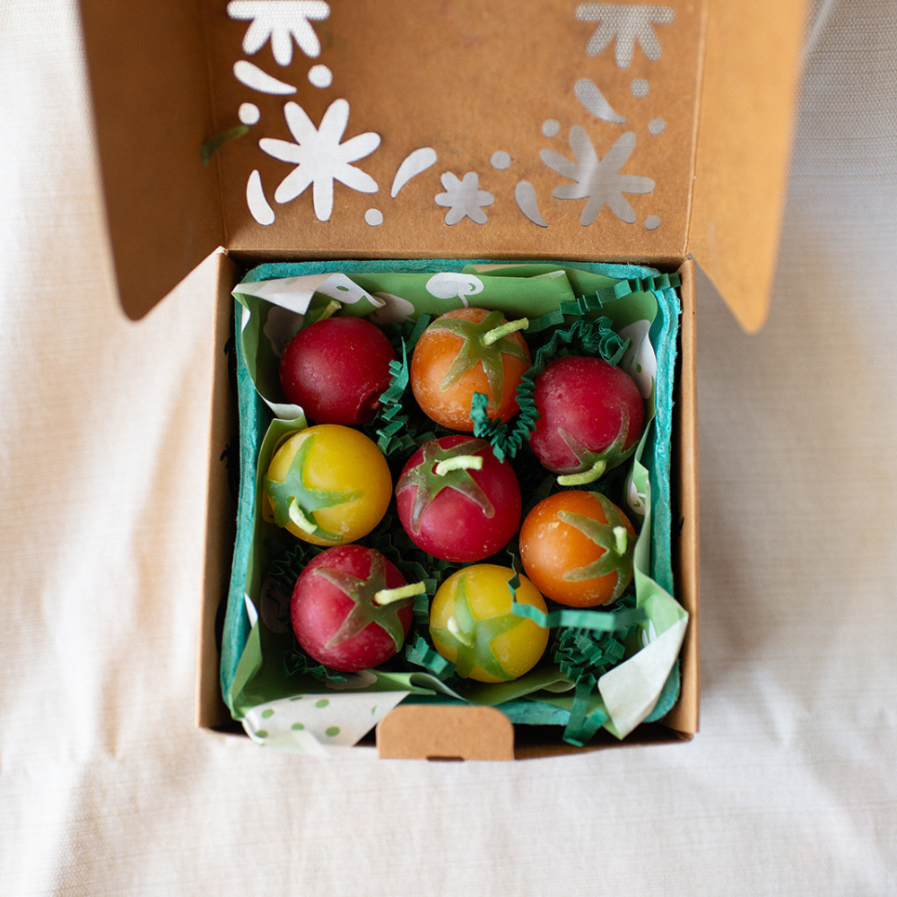 Box of decorative tomatoes with a floral design on the lid