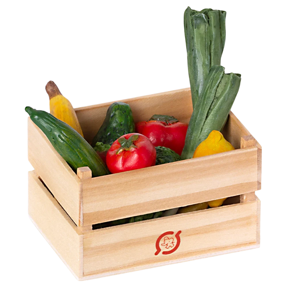 A wooden crate filled with miniature play fruits and vegetables, including carrots, cucumbers, and tomatoes.