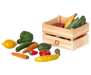 Wooden crate with toy vegetables and fruits on a white background