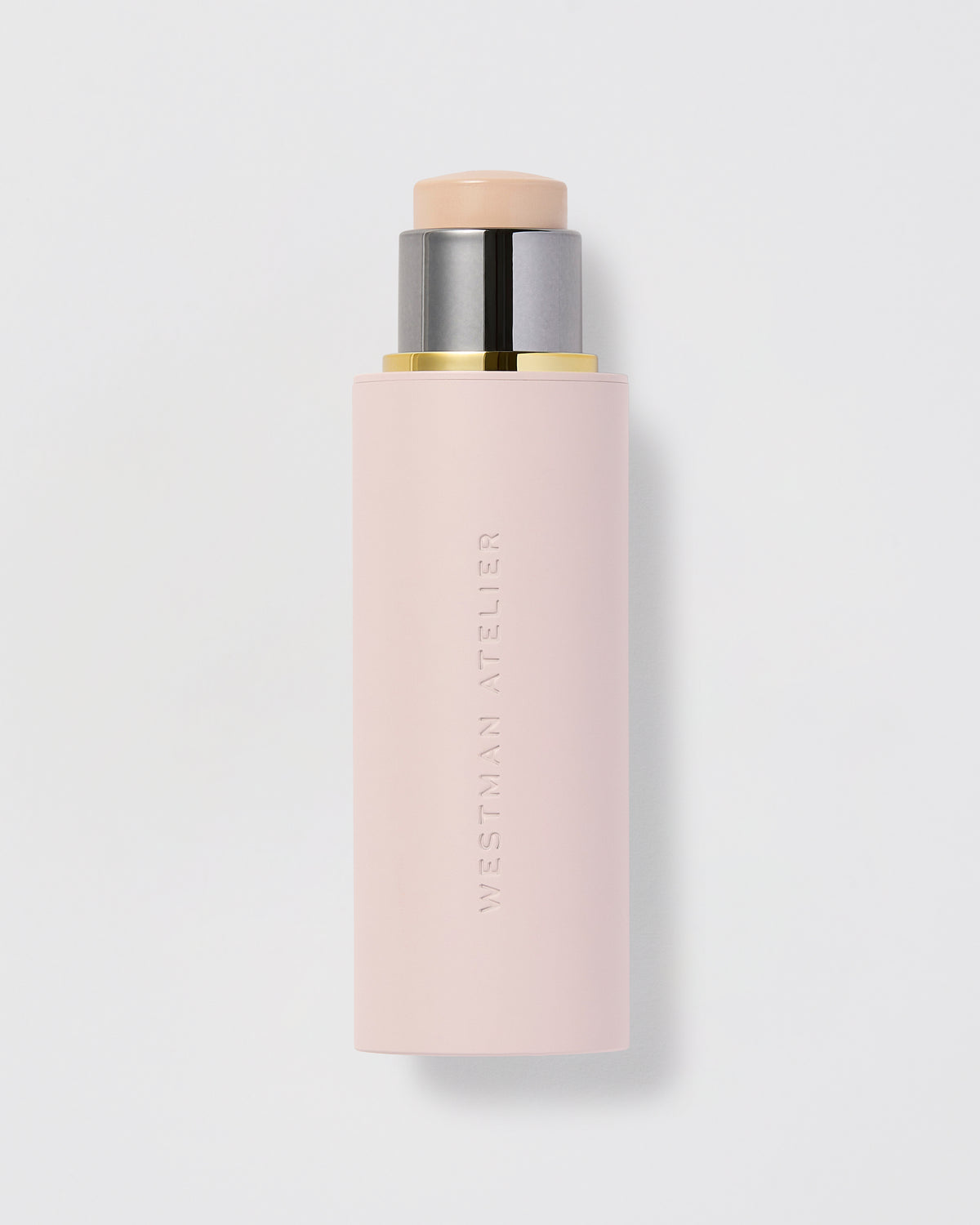 A stick of Westman Atelier Vital Skin Foundation with a pale pink tone, packaged in a sleek, cylindrical container.