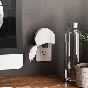 A Vitruvi plug in diffuser on a grey wall