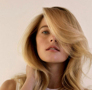 A woman with long blonde hair stares at the camera