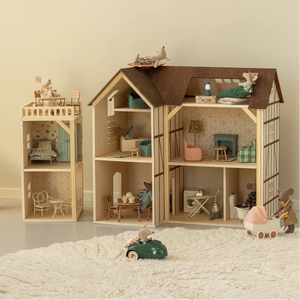 Wooden dollhouse with furniture and toys on a neutral background