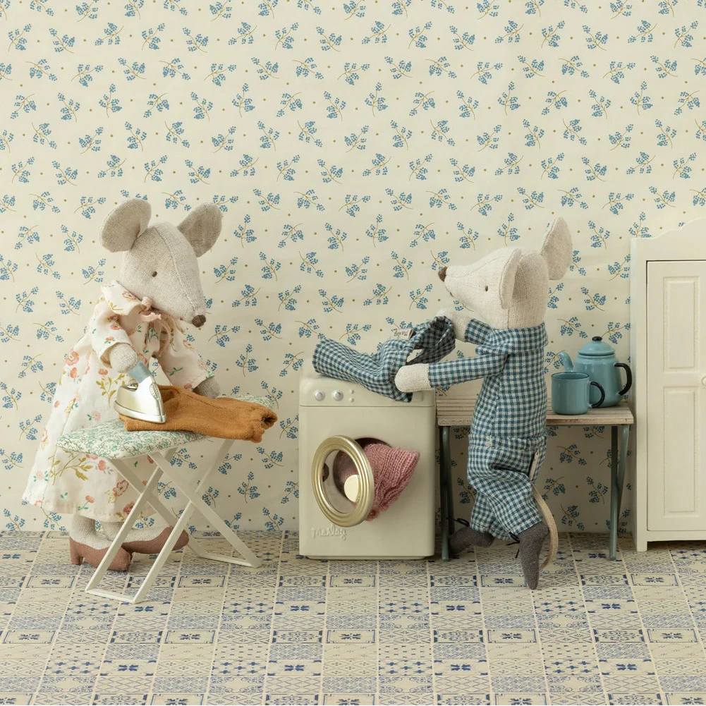Two mice in a playful setting with floral wallpaper and vintage furniture.