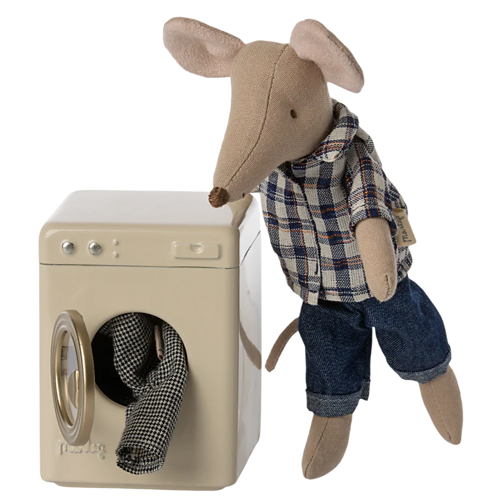 Stuffed mouse toy in plaid shirt and jeans next to a washing machine.