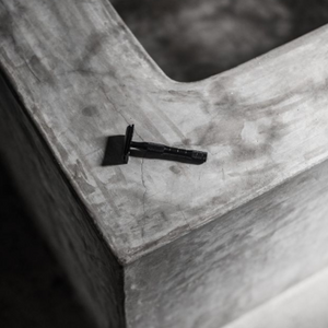 A black well kept razor on the side of a tub. 