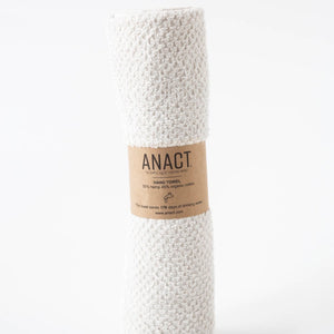White textured hand towel with a brown label on a white background