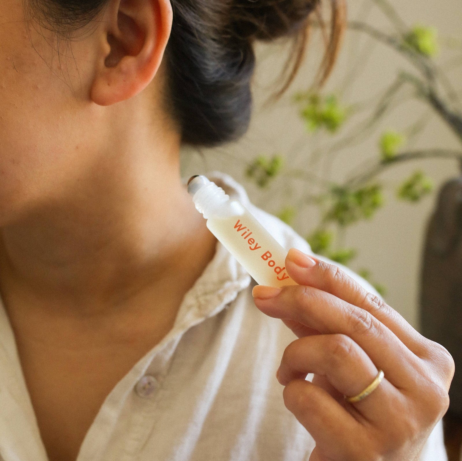 A bottle of Wiley Body Uplift next to a beige box on a cream background. 