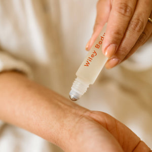 A woman applying Wiley Body balance roller to her wrist. 