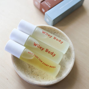 Three Wiley Body roll on sticks in a cream colored dish. 