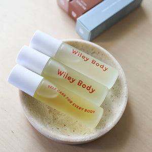 Three bottles of Wiley Body rollers in a cream dish. 