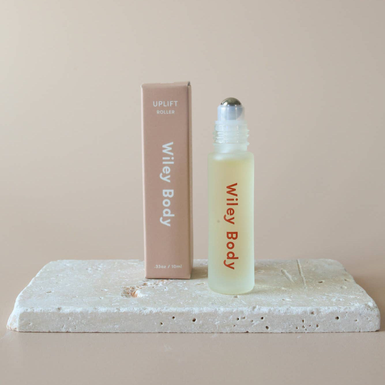 A bottle of Wiley Body Uplift next to a beige box on a cream background. 