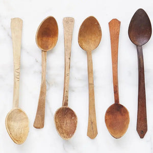 Six Found Wooden Spoons, on a white surface. 