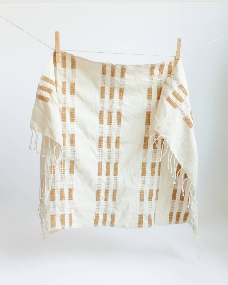 A yellow and white tea towel with a clothespin.