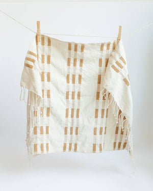 A yellow and white tea towel with a clothespin.